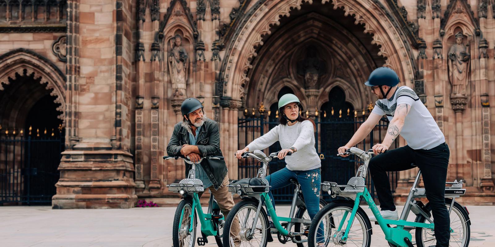 Three people sat in front of church on Beryl bikes