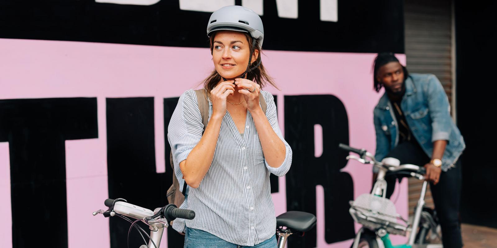 Woman fastening bike helmet to ride a Beryl Bike