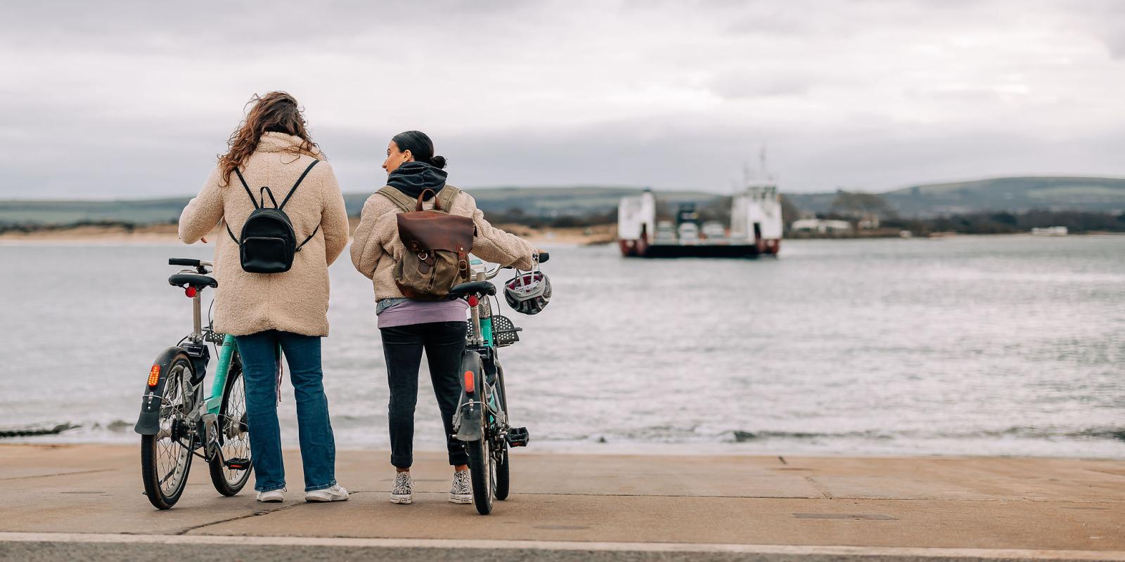 two women with Beryl bikes looking at the Studland chain ferry