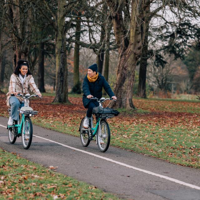 Man and woman riding Beryl bikes in a park