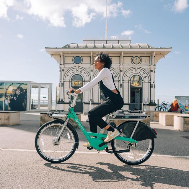 woman riding Beryl BTN e-bike on Brighton seafront