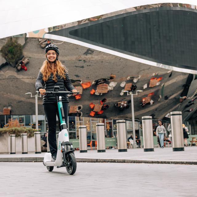 Man and woman riding Beryl e-scooters in front of the Bullring in Birmingham