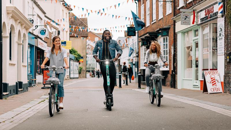 Three people on Beryl bikes and scooter