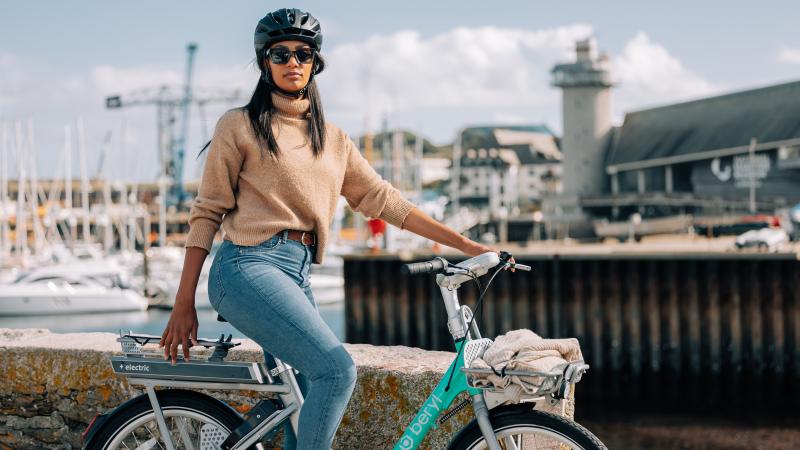 woman riding a Beryl e-bike by a harbour