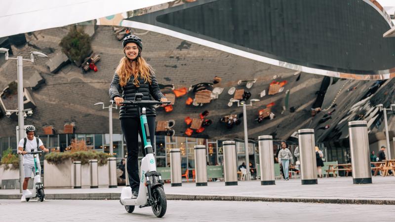 Man and woman riding Beryl e-scooters in front of the Bullring in Birmingham